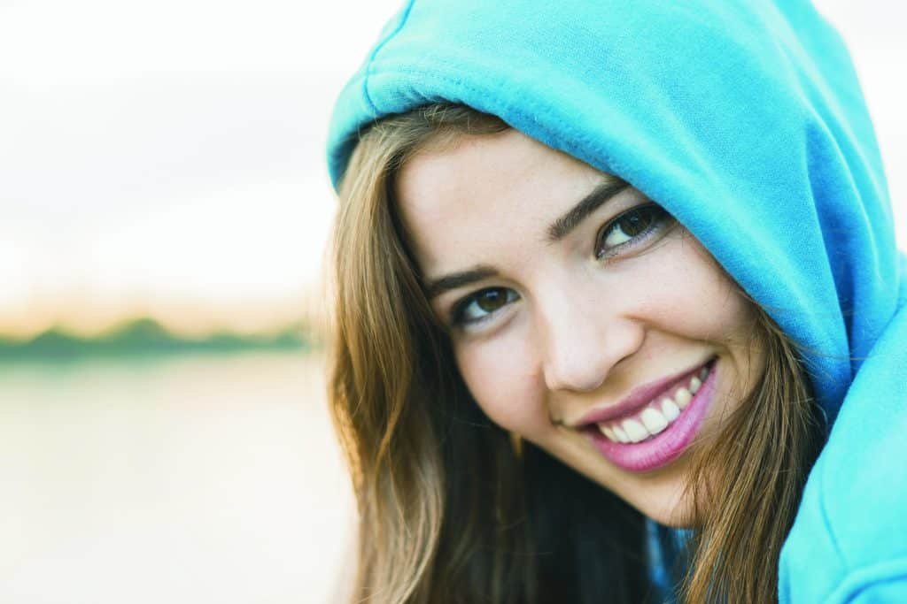 Smiling young woman in a blue hooded top